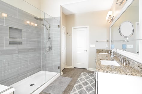 Large grey tile in oversized glass-enclosed shower