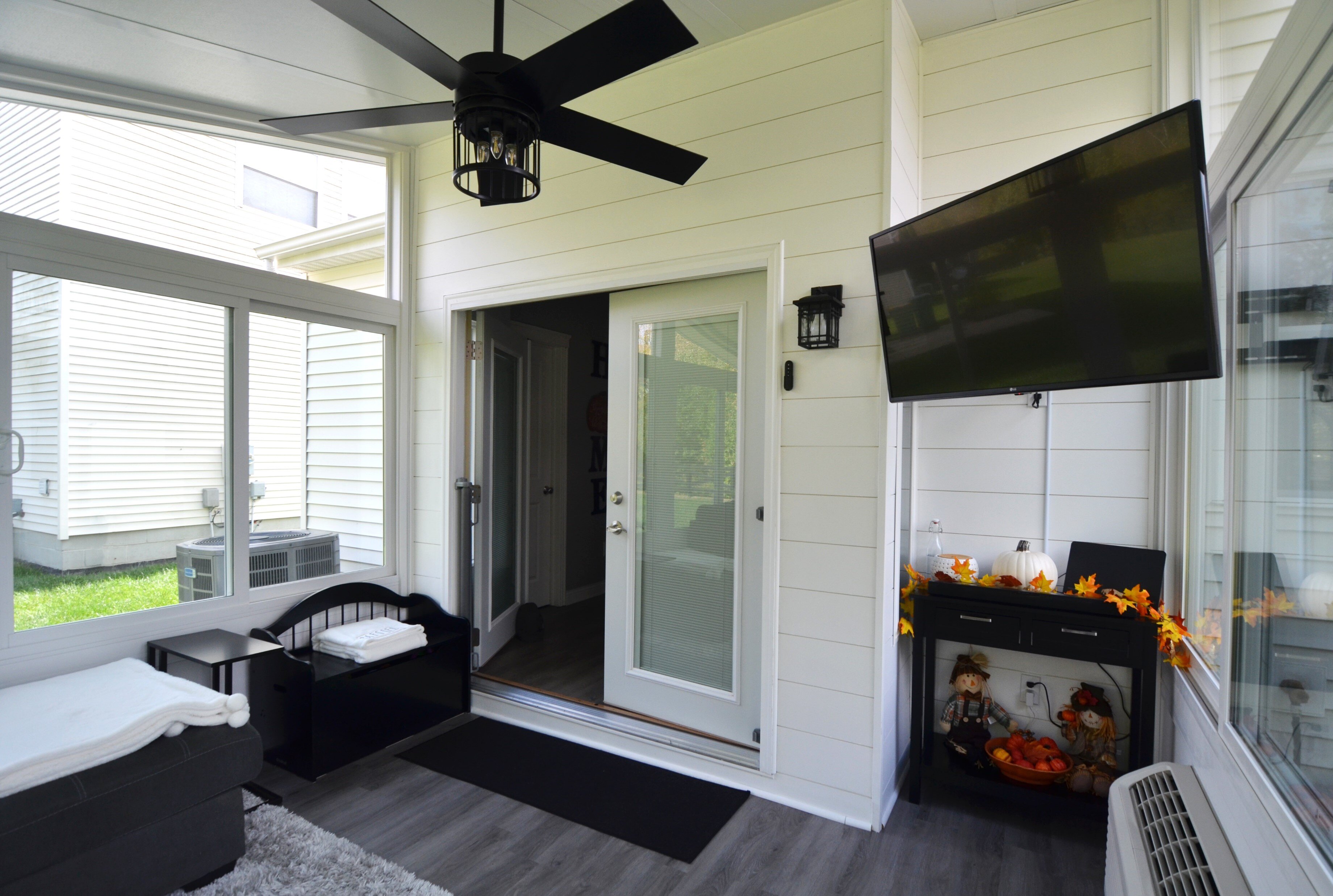 Interior of a sunroom featuring a TV mounted to the wall.