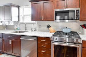 After picture of a cherry wood cabinets and white backsplash kitchen