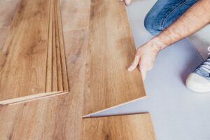 A person installing wood flooring in a home with JSB Home Solutions- Here are some tips!